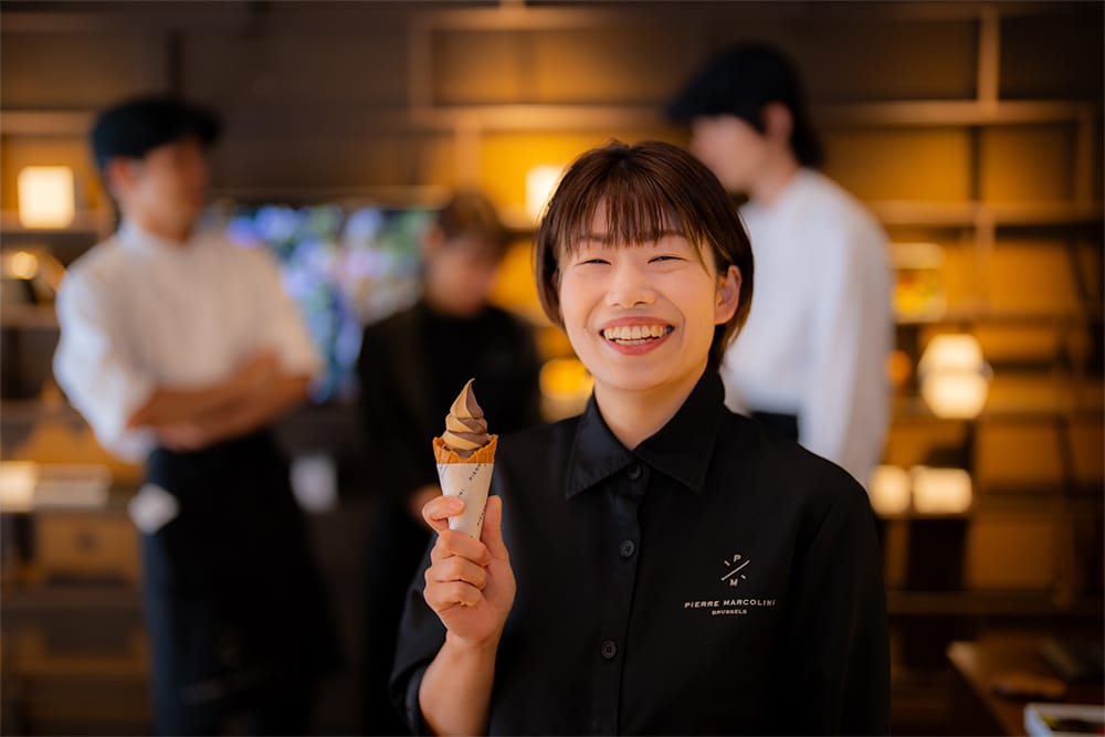 アイスを持って微笑んでいるスタッフの女性の写真